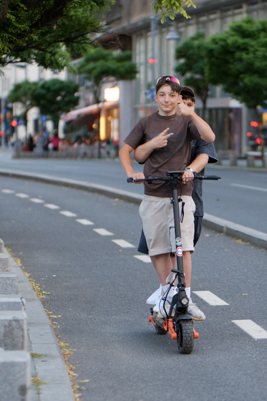 coming_soon_20 - Two individuals riding a Teverun Blade GT II electric scooter, which features large off-road tires and a digital display